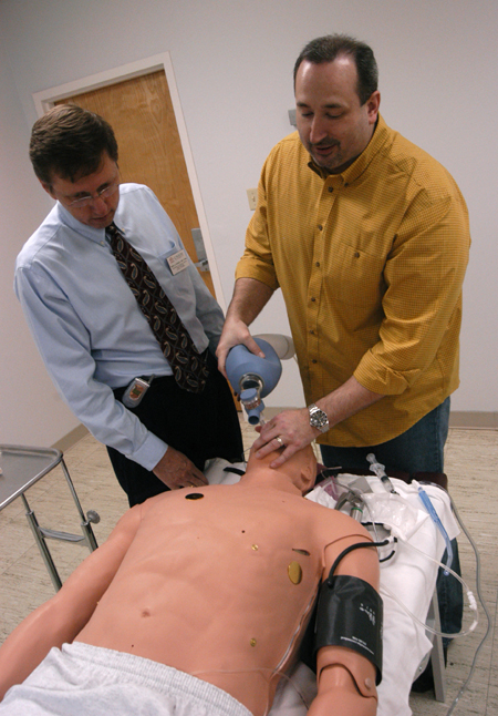 Mark Kossick, director of the nurse anesthesia program, demonstrates the Human Patient Simulator to graduate stuedent Dale Viox.