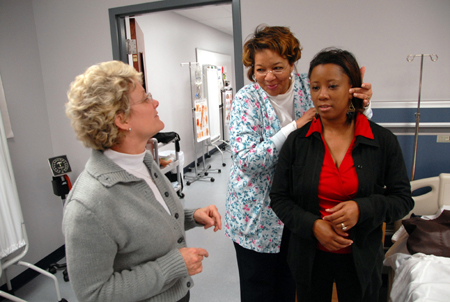 RN-BSN Student Sheila Anderson examines fellow student Ida Marie Todd while Pat Keene instructs them on proper techniques during a class on the Germantown campus.