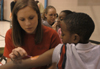Allison (Smith) Yates paints the arm of a young boy at the Jackson Boys & Girls Club during The Spring Fling.  The Spring Fling was an activity where the Club and SASW collaborated to make a day of excitement for at-risk kids while giving student social workers experience. - Photo by Heather Phillips