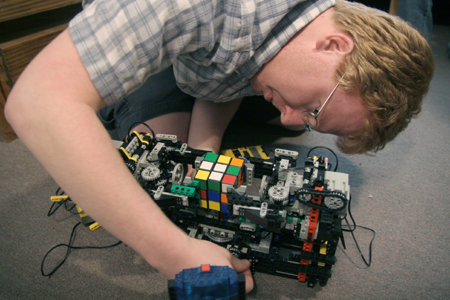 Junior Kendal Hershberger works on programming his robot made of Lego parts. The goal of the robot is to grab, pick up and solve the Rubik's cube based on a pattern from a computer program.
