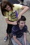Sophomore Sally Goulooze trims Chris Rigney's hair
outside of the Barefoot Student Union while enjoying the nice spring weather. - Photo by Stephanny Rodriguez