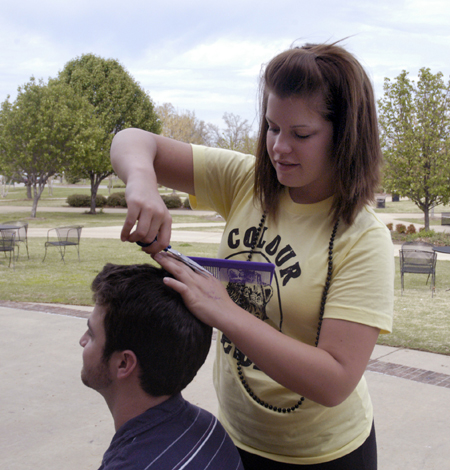 Sophomore Sally Goulooze trims Chris Rigney's hair
outside of the Barefoot Student Union while enjoying the nice spring weather.