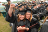 Jennifer Joan Winfield (left) and Kortney Lynn Baumgardner celebrate graduation in a rainstorm. Both received a bachelor of science degrees in nursing. - Photo by Morris Abernathy