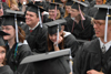 Spring graduates who had already been through the line honored the rest of the graduates by staying to the end in the rain. - Photo by Morris Abernathy