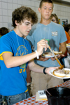 Matt Elia and Daniel Cathey grab some barbeque during New Student Orientation.  - Photo by Heather Phillips
