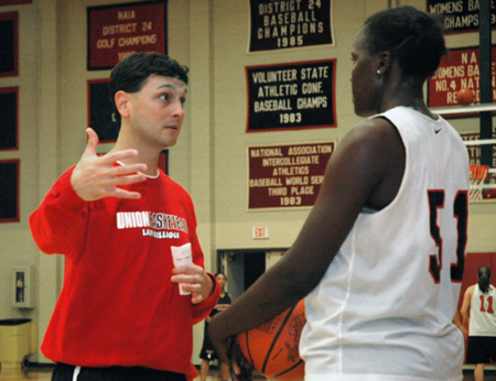 Mark Campbell, Head Coach of the Lady Bulldogs, gives direction to freshman center Josephine Owino.