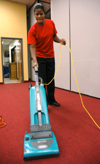 Senior Gladys Wandera, physical education major, runs a vacuum cleaner in Coburn dining hall, one of her three on-campus jobs. - Photo by Brad Moore