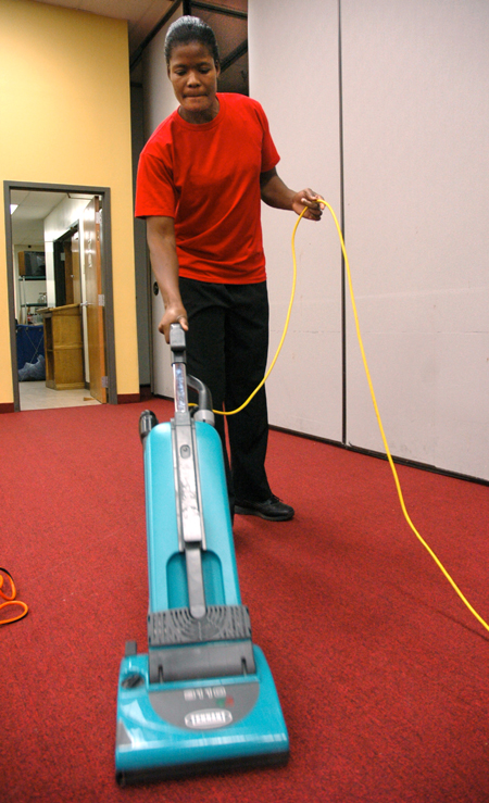 Senior Gladys Wandera, physical education major, runs a vacuum cleaner in Coburn dining hall, one of her three on-campus jobs.