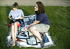 Angela White and Kristin Jennings relax in the grass in McAfee Complex while preparing for finals week. - Photo by Stephanny Rodriguez