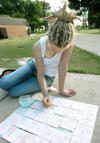 Erin Laverty paints tiles outside the art department during finals week. - Photo by Heather Phillips
