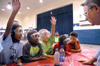 Dr. Charles Baldwin asks a group of children questions before performing a chemistry demonstration at the Lincoln Elementary School for <em>Mathematics and Science in Jackson</em>. - Photo by Brad Moore