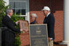 President David S. Dockery presents to Benny and Norma Fesmire a miniature version of the plaque that will be placed on the wall of the Fesmire Field House.  - Photo by Morris Abernathy