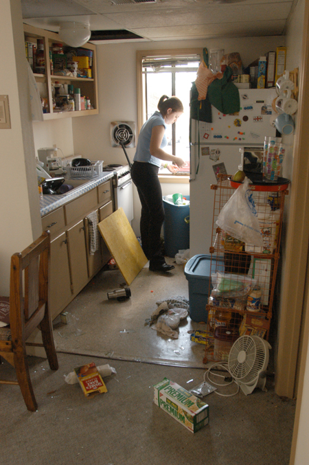Junior Sarah Thompson from Arkadelphia, AR begins the process of cleaning up the damage in her kitchen as a result of the tornado that came through on Saturday night.