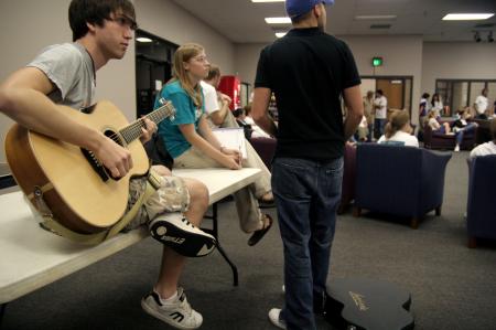 Jeffery Harper prepares and tunes his guitar before playing a couple of songs at the New Student Orientation open mic night.