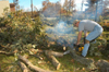 Christian Studies professor Paul Jackson uses a chainsaw to help clear trees downed by the tornado behind the McAfee Residence Complex. - Photo by Jim Veneman