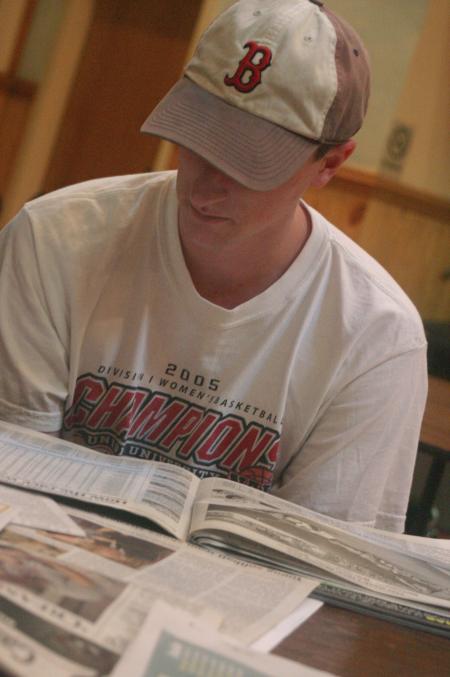 Senior David Roach, sports editor, reviews other newspapers at the Cardinal & Cream retreat to get new ideas for the new year.
