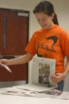 Senior Jenni Betts, managing editor, flips through previous issues of the Cardinal & Cream. - Photo by Stephanie Schroeder