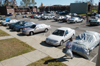 The parking lot at the McAfee Residence Complex shows the volume of tornado damage done to personal vehicles.  The clean-up volunteers spent many hours on Monday sweeping up glass and other debris from the parking lot. - Photo by Jim Veneman