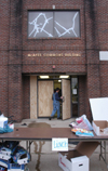 During the tornado the front windows of the McAfee Commons were blown out.  Here we see McAfee Residence Director Dan Herr entering the temporarily repaired commons after organizing a lunch for the clean-up volunteers.  - Photo by Jim Veneman