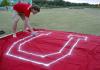 Ronald Long decorates paints the U on a flag for the pep rally march. - Photo by Kyle Kurlick