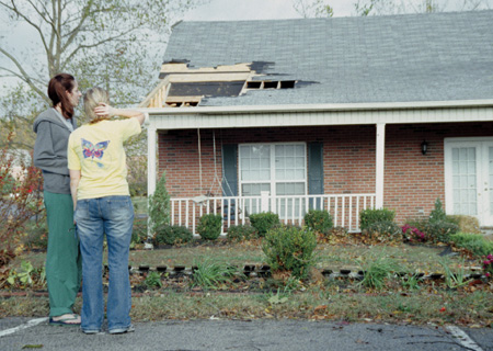 Senior Nicole Geyer, biology major, and junior Ashley Larue, public relations major, examine the damage done to the Kappa Delta house after the tornado.