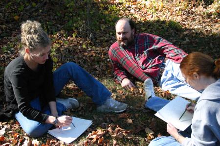 Professors Lee Benson and Lori Nolen talk with Angela McDaniel, art department secretary, as they participate in a drawing project during the art retreat.