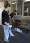 Freshman Brittaney Cole, undecided major, and Freshman Kristen Walker, nursing major, clean up the waiting room at Youth Town for a Day of Remembrance project.  - Photo by Heather Phillips