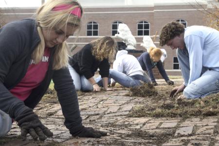 Stephie Glass, Blake Waggoner and others clear weeds from the walkway outside of The Care Center located near downtown Jackson during Day of Remembrance.