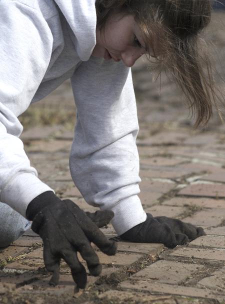 Carolyn Jennings weeds out a walkway at The Care Center during Day of Remembrance.