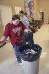 Sophomore Megan March empties the dust pan after sweeping the floors at The Salvation Army during Day of Remembrance. - Photo by Stephanie Schroeder