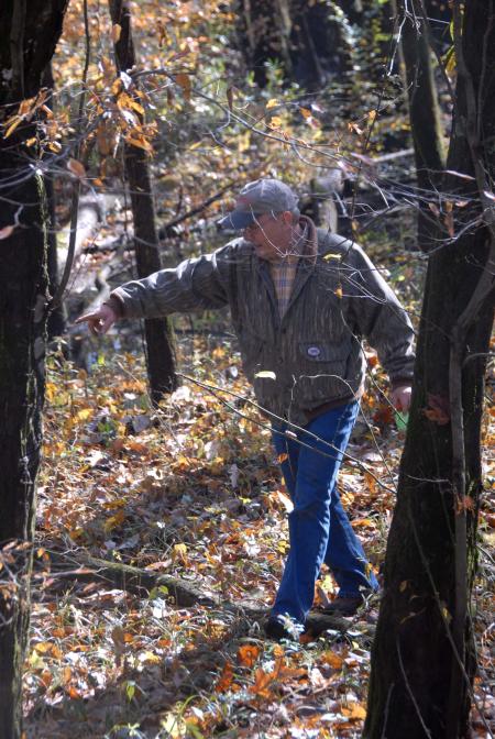 Dr. James Huggins goes off the boardwalk to pick up trash at Cypress Grove during Day of Remembrance.