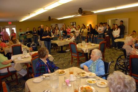 Richard Joiner and his choral students sing at The Oaks Nursing Home on Day of Remembrance. The residents joined in singing with the students.