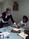 Amy Brown with GO Thailand helps Rose Young place her bingo chip on her board at the Mission Convalescent Home during Day of Remembrance.  - Photo by Beth Spain
