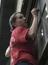 SAC Member Kasey Cobb diligently scrapes the paint off the windows of the Young Life house as a part of Day of Remembrance.  - Photo by Beth Spain