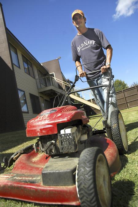 Mike Growe goads his mower forward inside the Hurt Residence Complex, taking care to mow in straight even lines. Wherever grass is inaccessible by riding mower, such as inside the complexes, groundskeepers must use a push-mower.