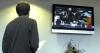 Alum and Enrollment Counselor Brad Spencer watches fall graduation on screen in the lobby at West Jackson Baptist Church. - Photo by Matthew Diggs