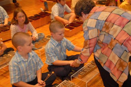 Betty Bedsole, professor of music, works with members of the Children's Choir on Orff instruments.