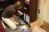 Christie Pawley, instructor of nursing, stacks the last of her books on the shelves in her new office in White Hall. - Photo by Stephanie Schroeder