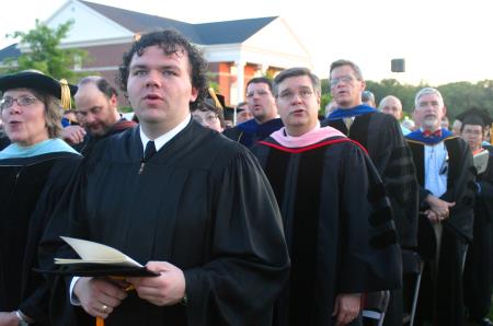SGA President Josh Clarke sings the Union University Alma Mater along with the faculty at the end of graduation.