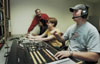 Steve Beverly, assistant professor of communication arts, works with his broadcasting students in the control room of the television studio. - Photo by Jim Veneman