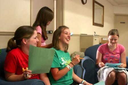 Molly Merck, Chelse Lampley and Jessica Pikowski laugh as they and other Rising Senior students discuss a plan of survival test.