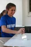 Devon Sledd paints cabinet doors as a part of a Rising Senior project at The Care Center in downtown Jackson. - Photo by Stephanie Schroeder
