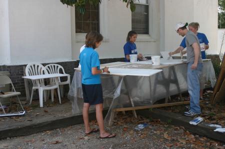 Chelse Lampley, Devon Sledd, Justin Phillips and Victoria Allen paint cabinet doors as part of a Rising Senior project at The Care Center in downtown Jackson.