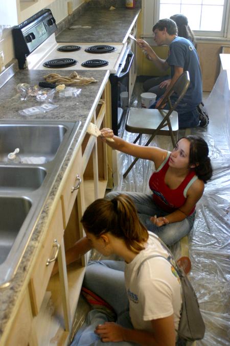 Rising Seniors paint cabinets and doors as part of a project at The Care Center in downtown Jackson.