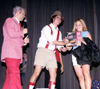 Freshman Kelly Fern is presented with a lovely parting gift at <i>Right is the Price</i> by Graham Mayfield and host Mark (VanderHaar) Marker. - Photo by Mykle Harchfield Johnson