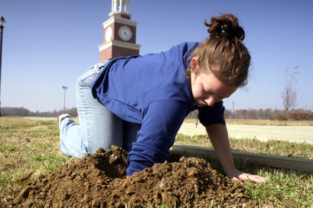 Lesley Robinson clears out a hole for the poles in the September 11 memorial environmental installation.