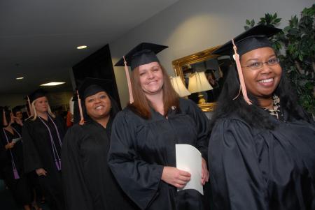 Smiling graduates prepare to march into the August graduation ceremony.