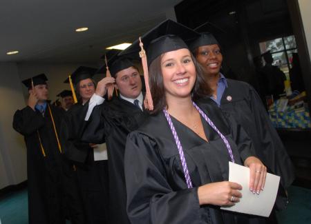 Smiling graduates prepare to march into the August graduation ceremony.
