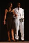 Sophomore Darrion Garrett is accompanied by an escort as he shows off his evening wear during Mr. Campus. - Photo by Stephanie Schroeder