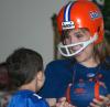 McAfee Residence Director Ashley Jackson and her son, Matthew, cheer on University of Florida in a game against University of Tennessee as they watch it projected on a wall in the McAfee Commons. - Photo by Stephanie Schroeder